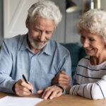 60s elderly spouses at lawyer office sign marriage contract